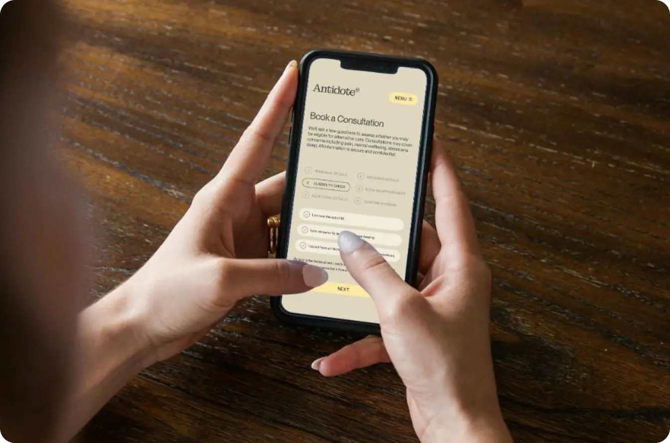 A person holding a phone showing the Antidote booking screen